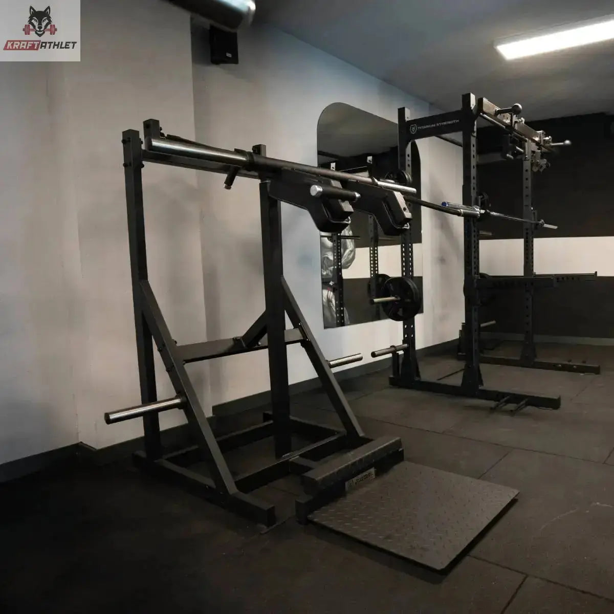Titanium Strength Elite Series Viking Press und Stehender Wadenheber im Studio auf Gummiboden, Schrägansicht mit Bodenplatte