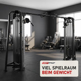 Titanium Strength Genesis Series 2-Station Cable Crossover in einem fertig eingerichteten Studio mit dunklen Wänden und Gummiboden