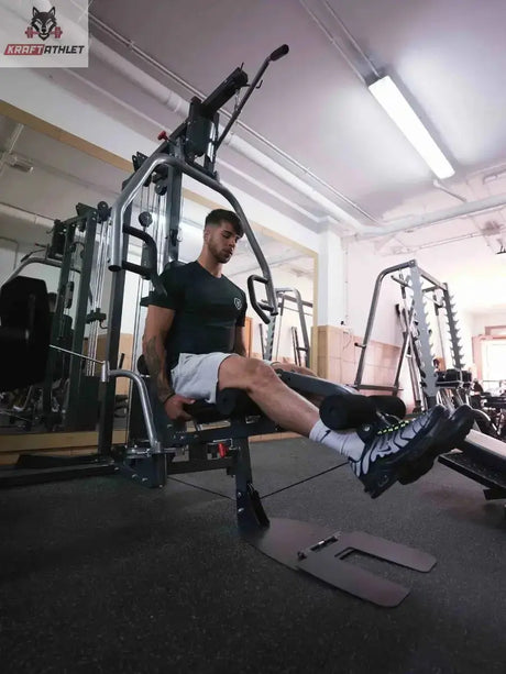 Titanium Strength Multi-Gym MG1: Athlet trainiert am Beinstrecker im Studio