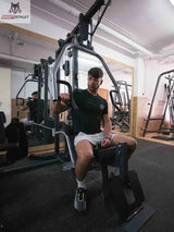 Titanium Strength Multi-Gym MG1: Athlet sitzt an der Station und greift den Butterfly-Arm