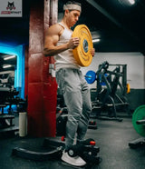 Titanium Strength SS120 Sissy Squat im Einsatz, Mann in aufrechter Position mit gelber Hantelscheibe