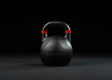 Younix Competition Kettlebell 16 kg Gusseisen, Frontansicht der Variante 8 kg in Schwarz vor dunklem Hintergrund