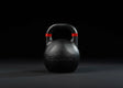 Younix Competition Kettlebell Set Intermediate: schwarze Kettlebell mit rotem Streifen vor dunklem Hintergrund