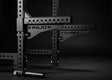 Younix Half Safety Bars Sicherheitsablagen: zwei schwarze Ablagen mit Lochraster am Rack, Schrägansicht vor dunklem Hintergrund