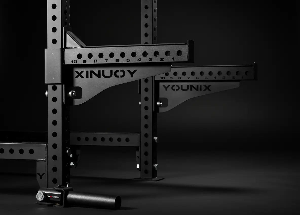 Younix Half Safety Bars Sicherheitsablagen: zwei schwarze Ablagen mit Lochraster am Rack, Schrägansicht vor dunklem Hintergrund