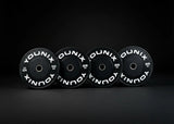 Younix Premium Bumper Plate 20 kg Hantelscheibe, vier schwarze Scheiben stehend vor dunklem Hintergrund