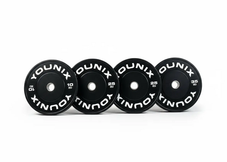 Younix Premium Bumper Plate 20 kg Hantelscheibe, vier schwarze Scheiben in einer Reihe vor weißem Hintergrund
