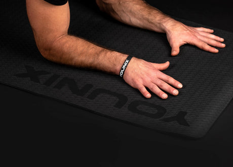 Younix Workout Mat Trainingsmatte in Schwarz, Hände auf der Matte, Detail der geprägten Oberfläche